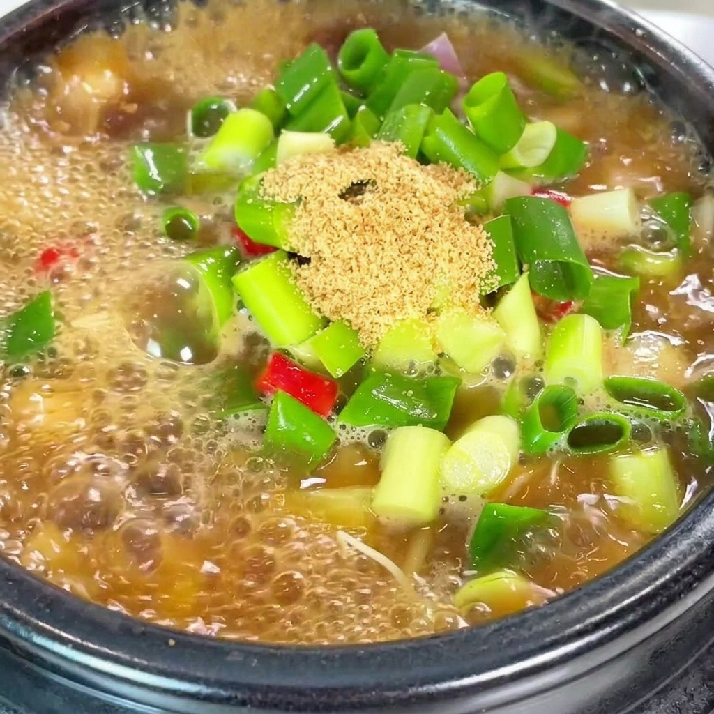 牛肉だしの素と粉唐辛子を鍋に加えているクローズアップショット。
