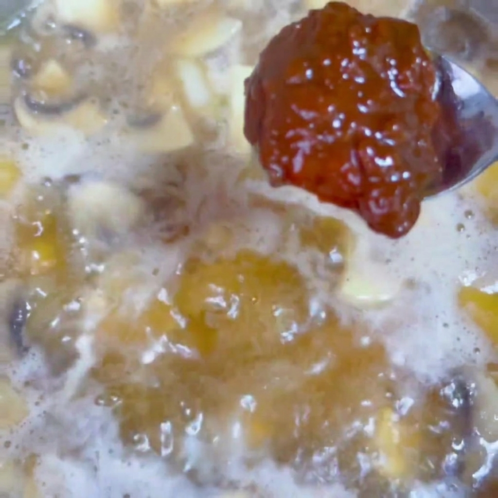 煮立っているスープに味噌を溶かし入れている様子。
