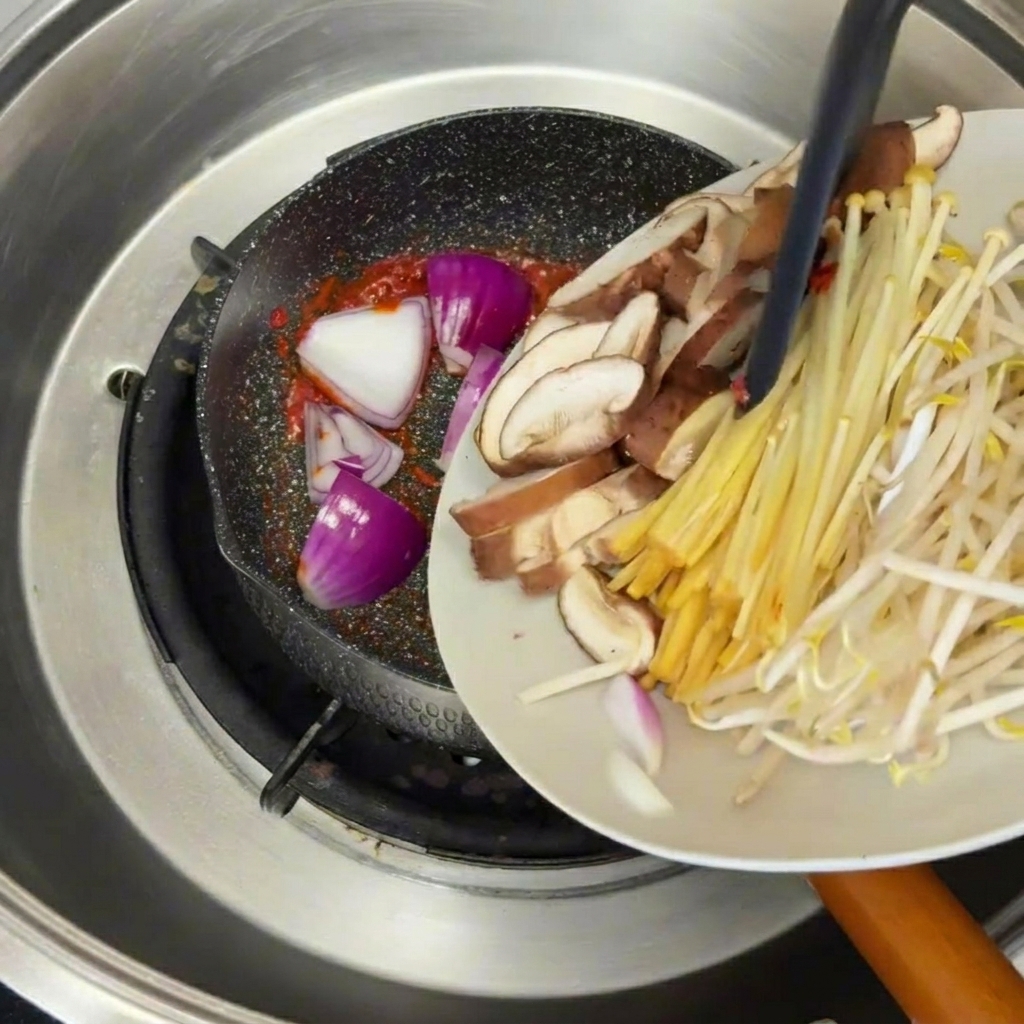 スープの表面にごま油を回し入れる様子。