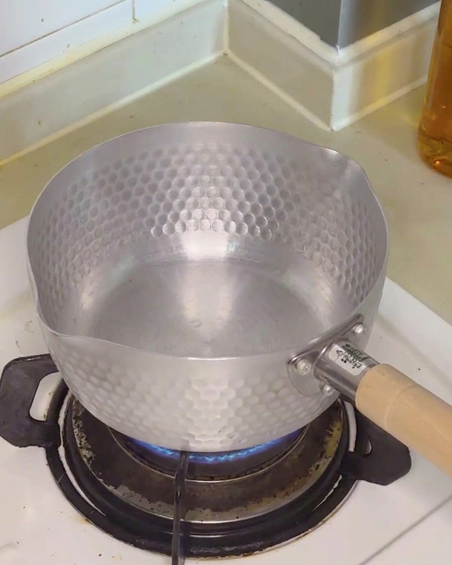 鍋に水を注いでいる様子。