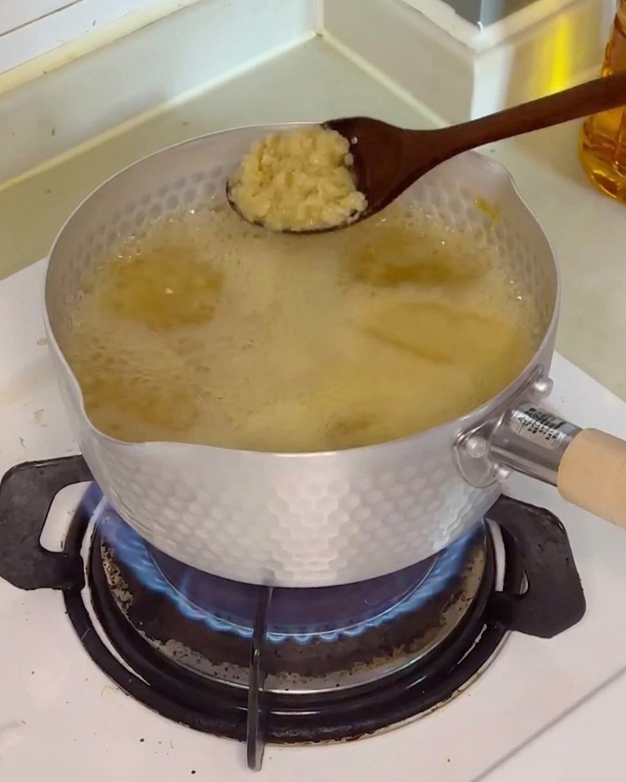 ニンニクをスープに加えている様子。