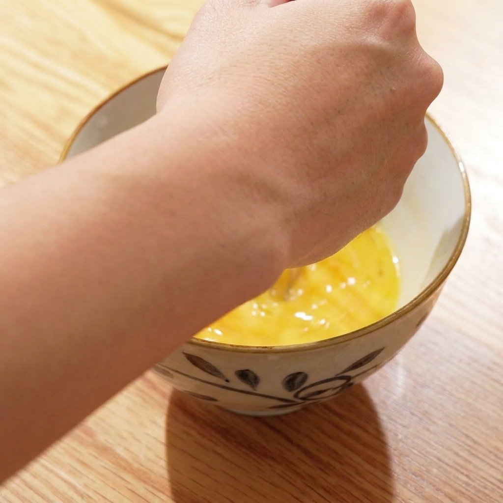 四顆雞蛋打入瓷碗中，準備攪拌。