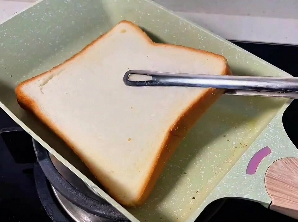フライパンで食パンを焼いている様子