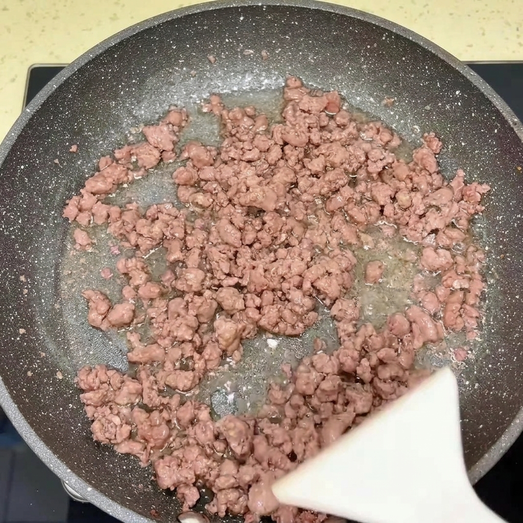 調理された牛肉と玉ねぎが入ったフライパン。