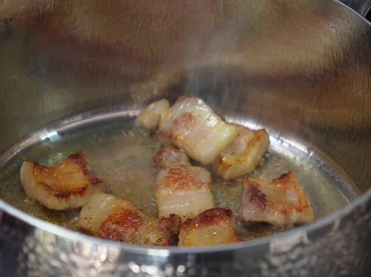 豚肉の脂でみじん切りのにんにくを炒めている様子。