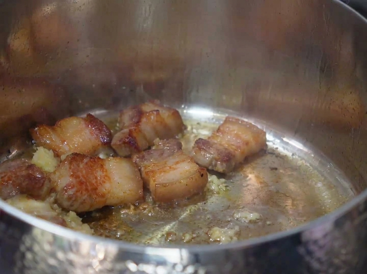 キムチを肉とにんにくと一緒に炒めている様子。