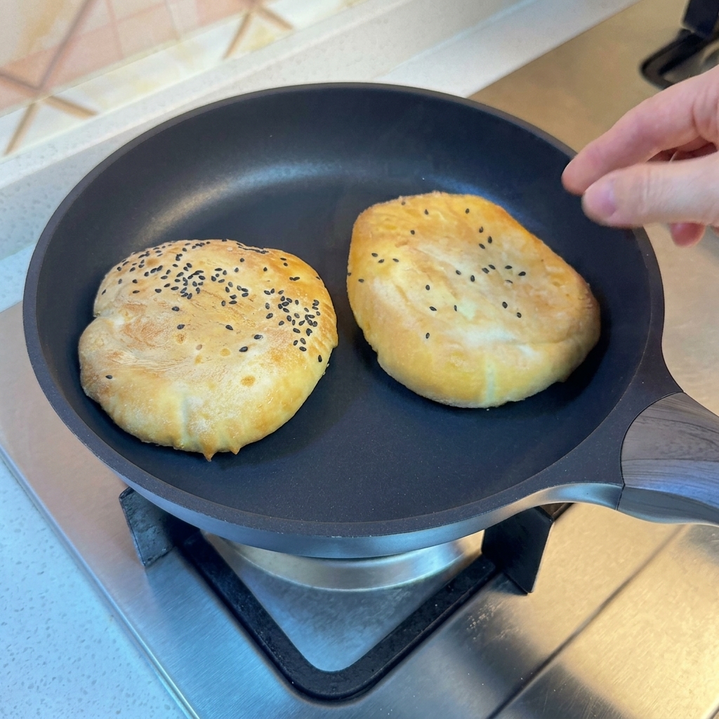 蓋をして蒸されているフライパンの中のバンズ。