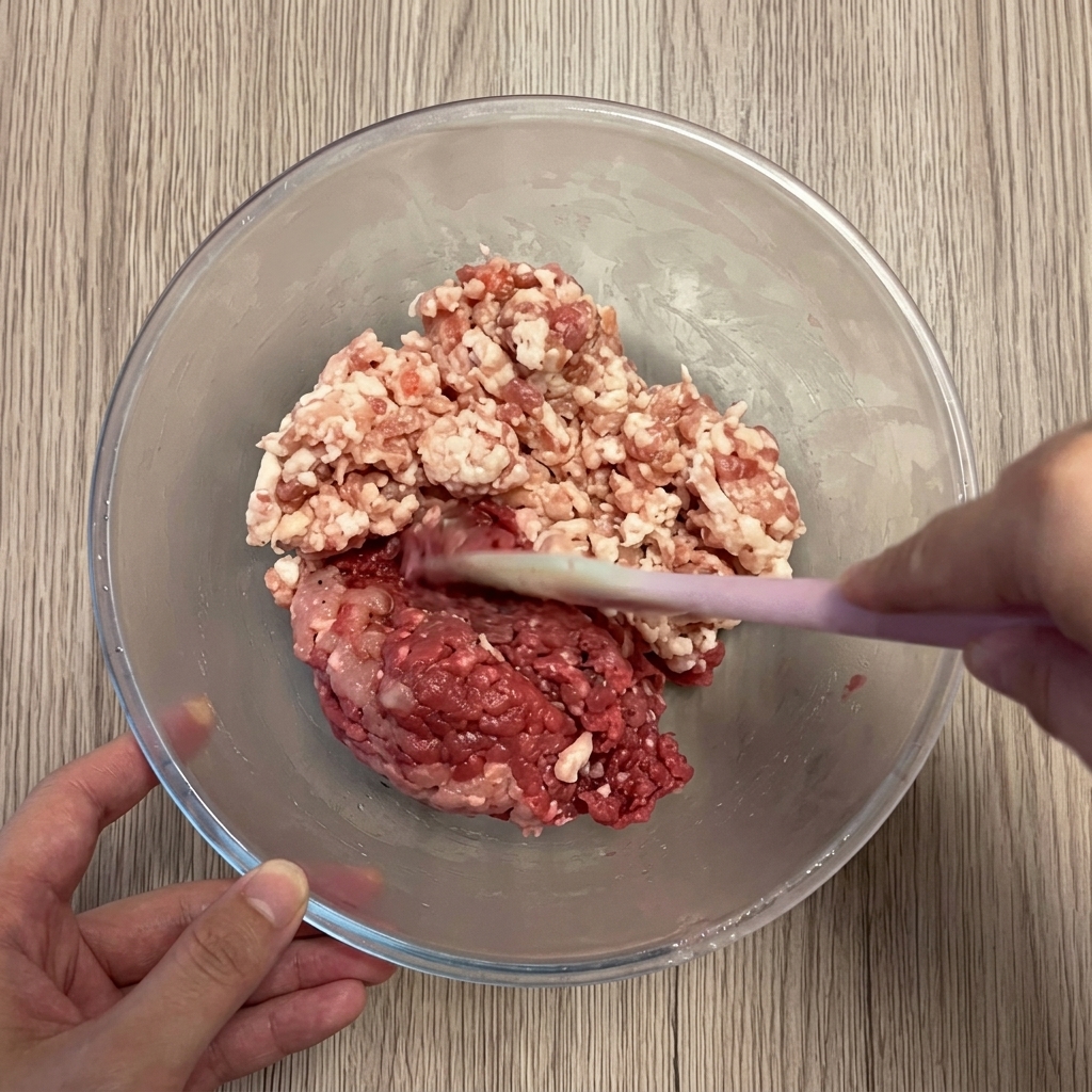 大きなガラスボウルに入った豚ひき肉と牛ひき肉。