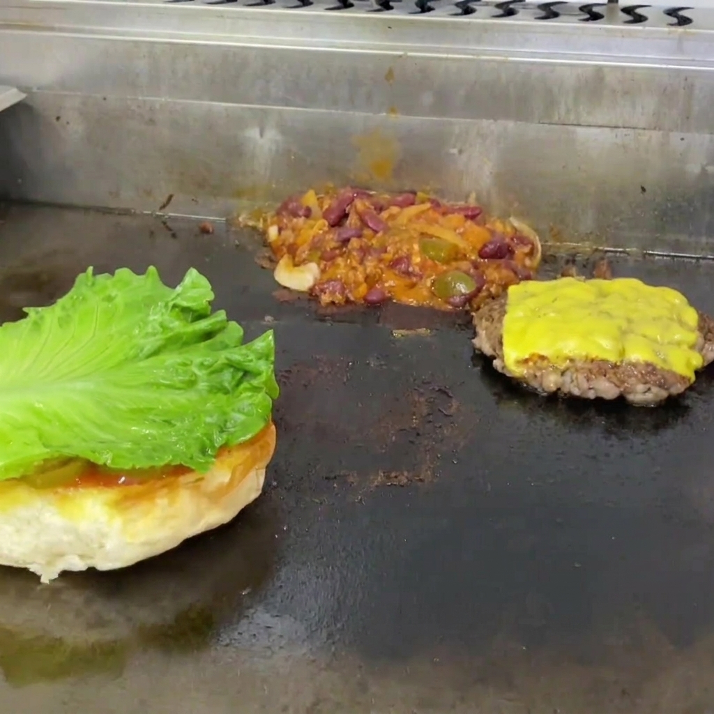 トーストした下のバンズにのせられたレタスとトマトスライス。