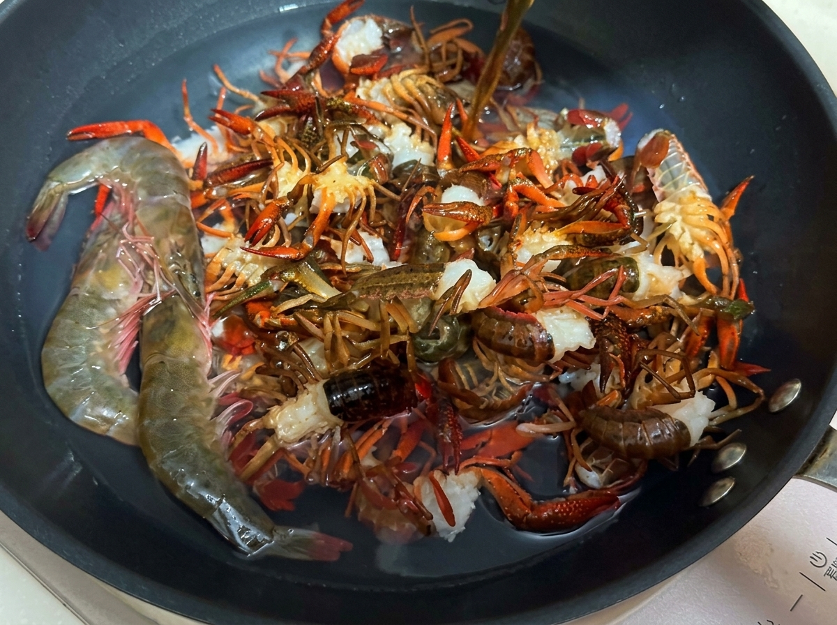 鍋で料理酒と共に下茹でされる新鮮なザリガニ。