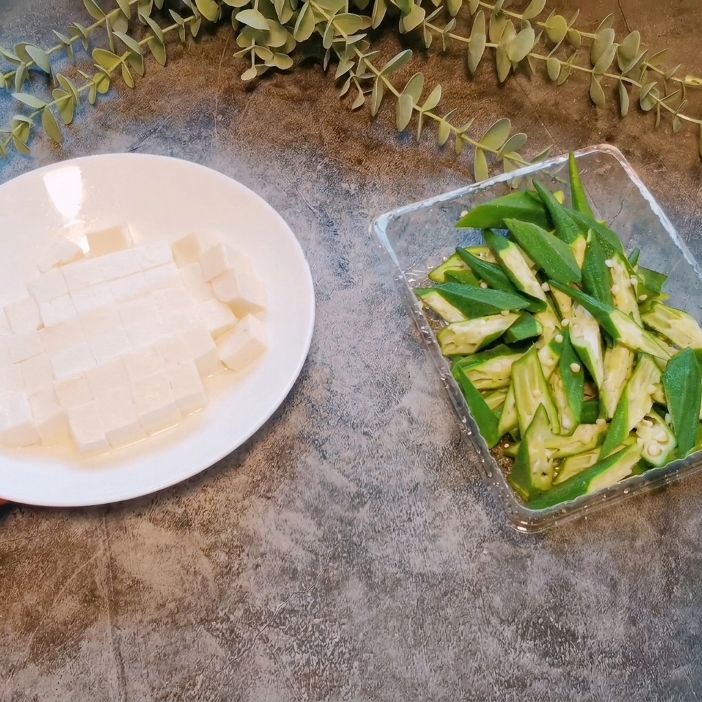 白い皿の上で、ソフト豆腐を小さく均等なサイコロ状にカットしている様子。