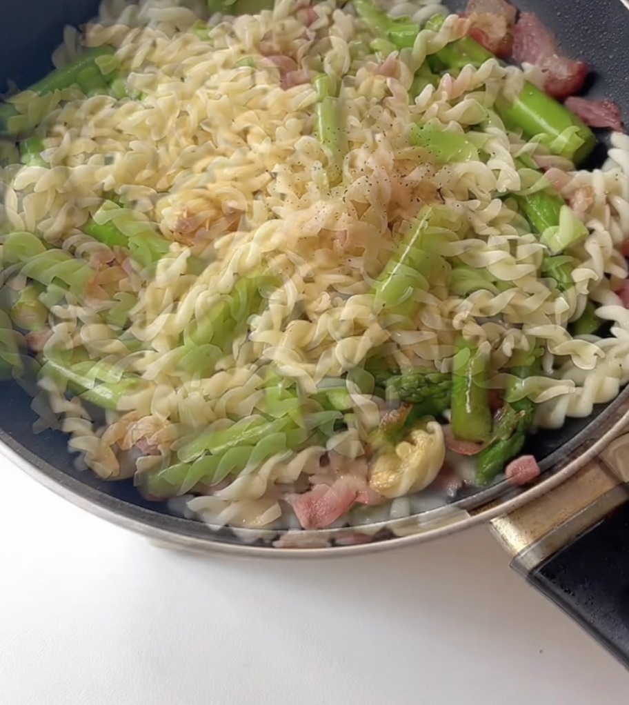 パスタに黒胡椒と醤油をかけて味を調える様子。