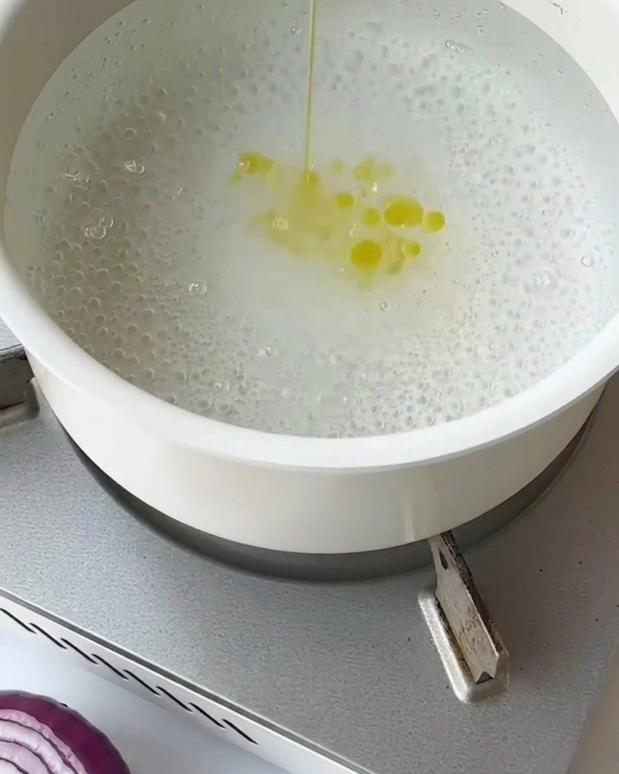 網じゃくしを使って、沸騰したお湯でアスパラガスを茹でている様子。