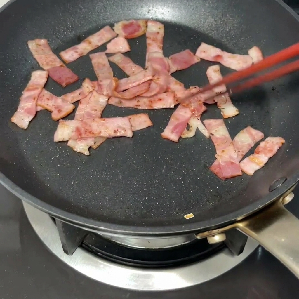 カリッと焼けたベーコンが入ったフライパンに、黄金色のバターが溶けていく様子。