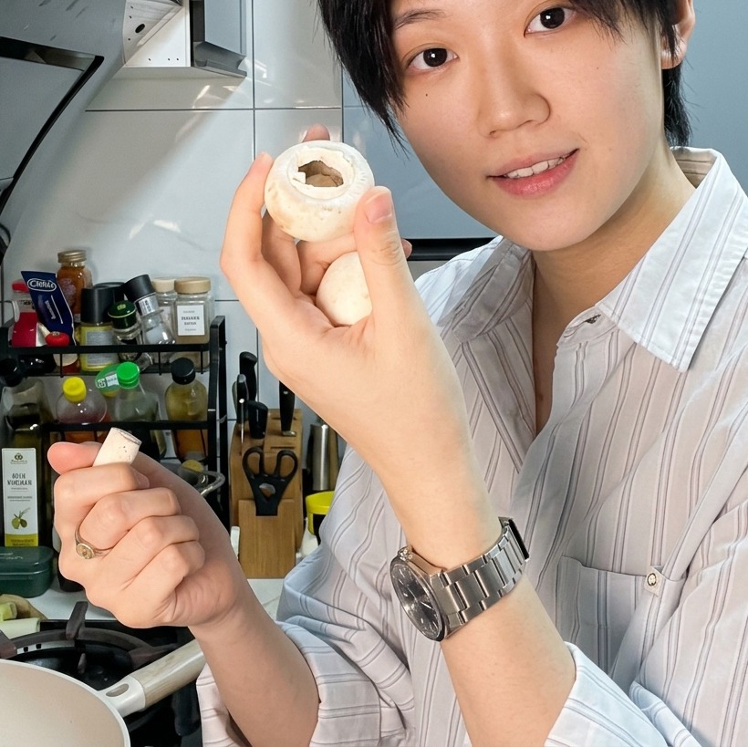 まな板の上でホワイトマッシュルームをスライスしている様子。