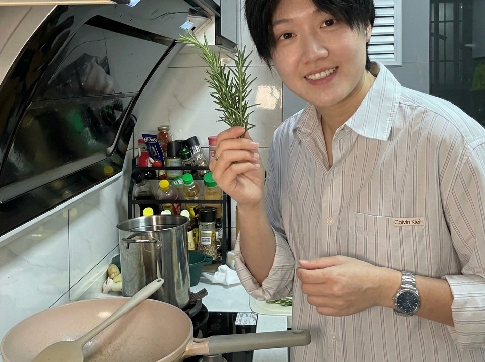 炒めたベーコンにフレッシュタイムの枝を加えている様子。