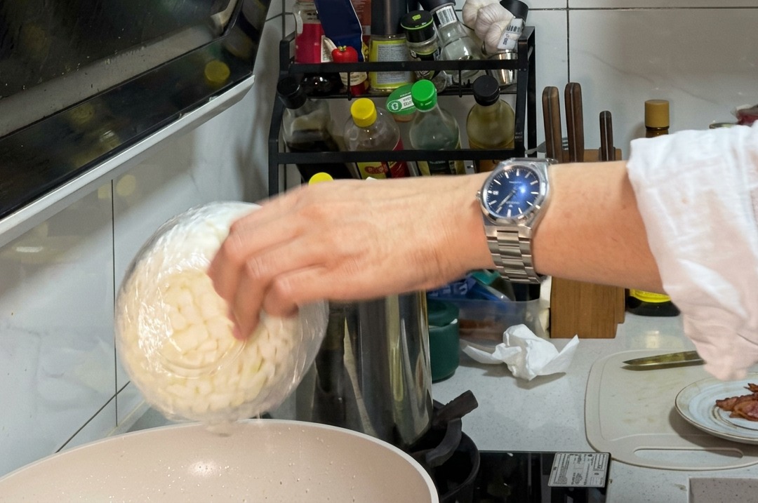 ベーコンの脂で玉ねぎとマッシュルームを炒めている様子。