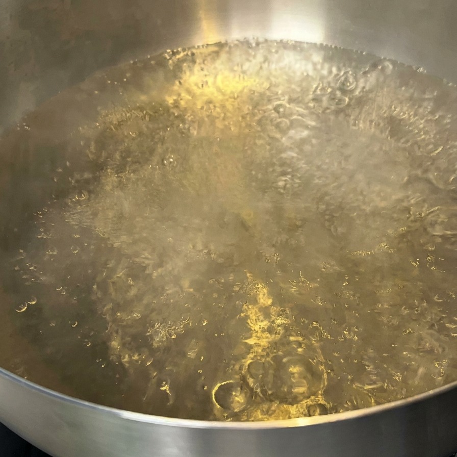 少量の油が浮かんだ鍋いっぱいの沸騰したお湯