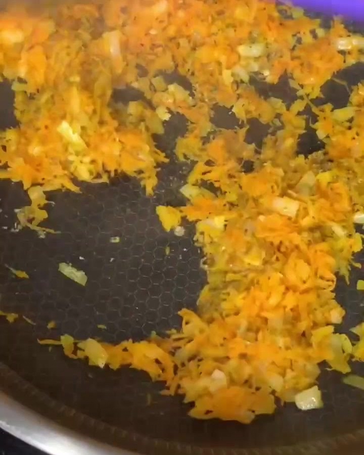 炒めた野菜とひき肉をフライパンで混ぜ合わせている様子。
