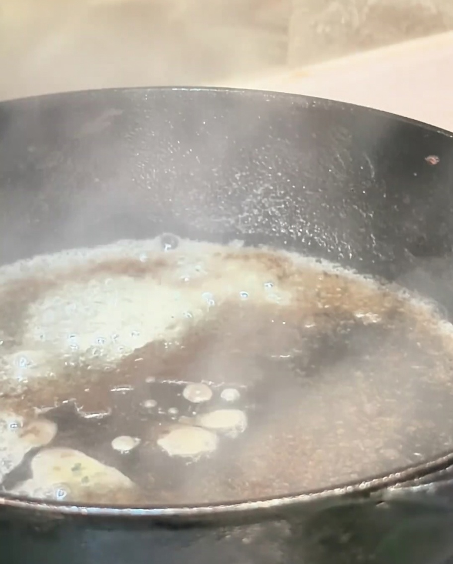 フライパンに液体を注ぎ、蒸気が上がっている様子。
