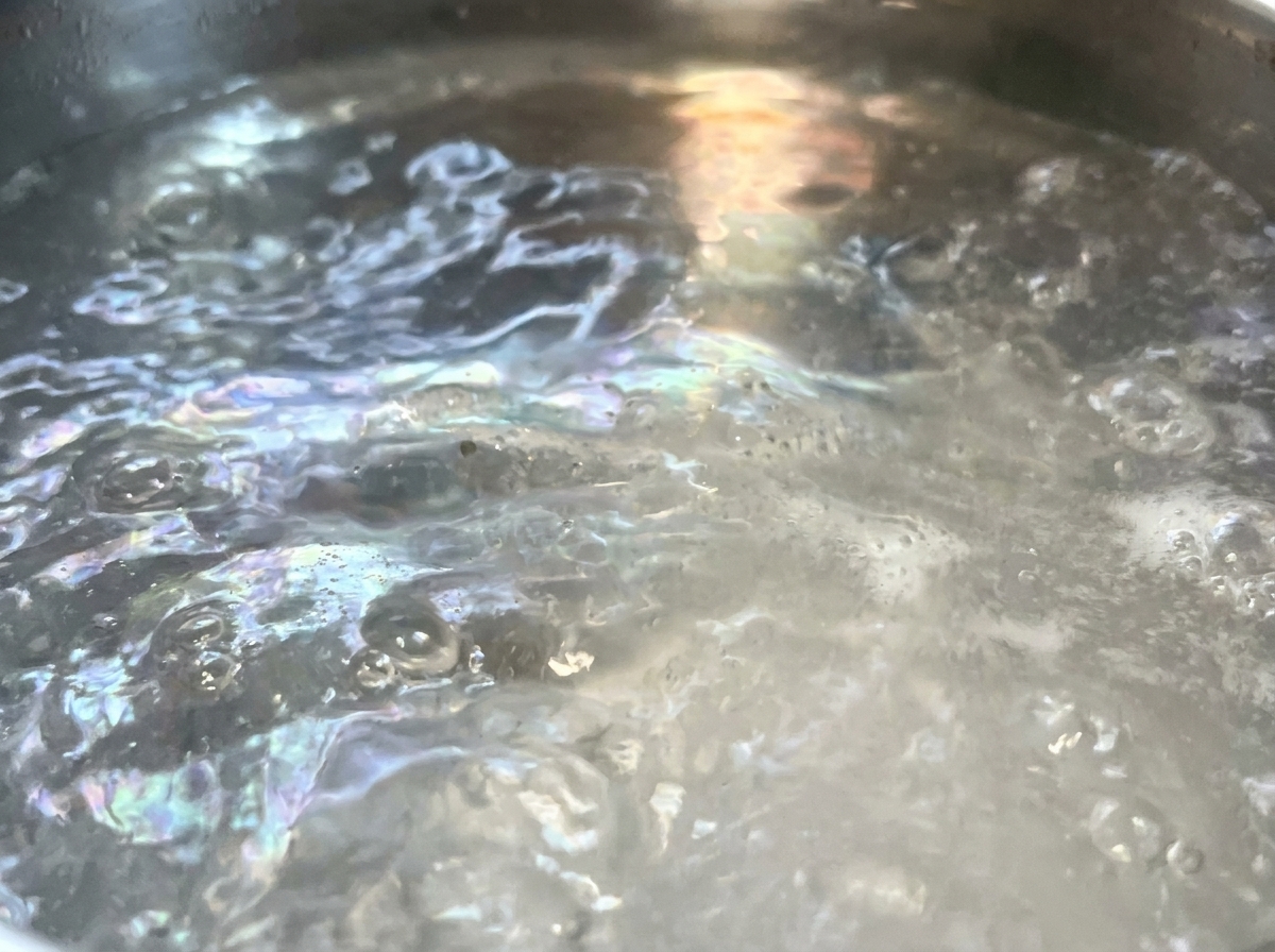 沸騰したお湯にスパゲッティを入れる様子。