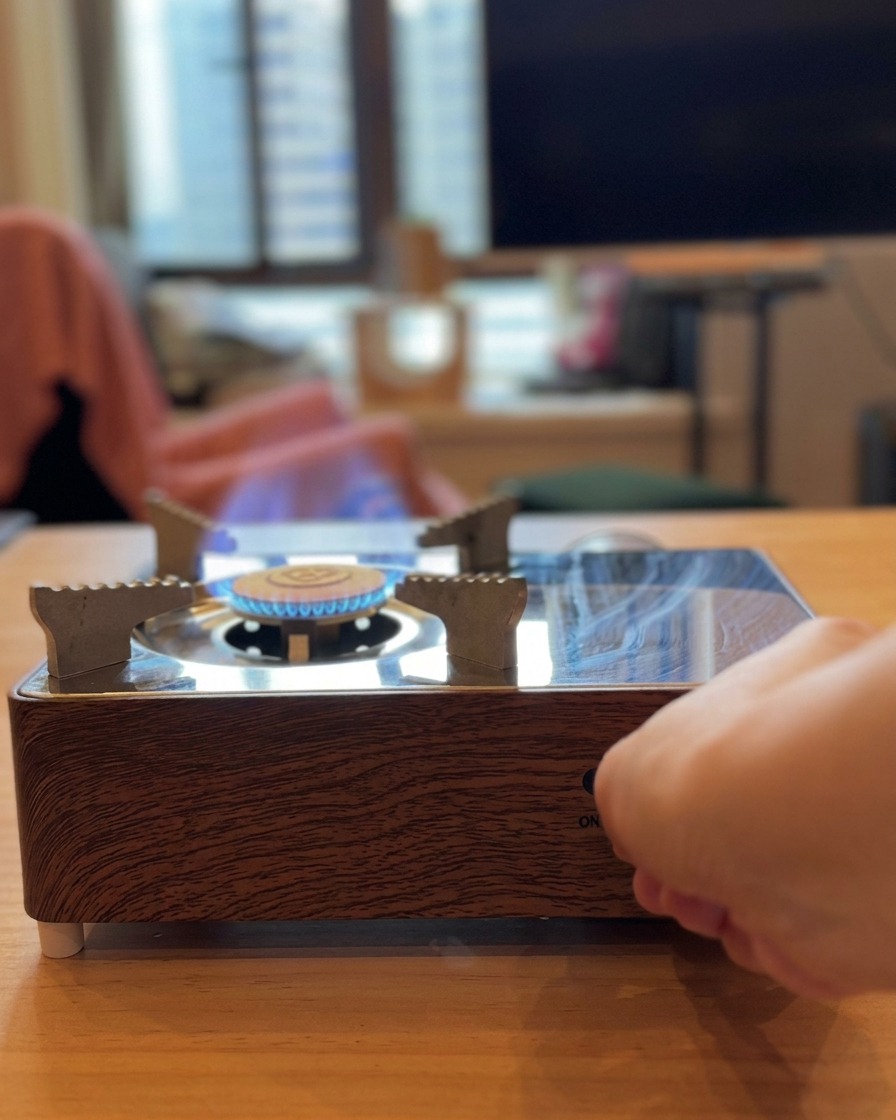 長い箸を使い、トマトを直火で炙って皮を焦がしている様子。