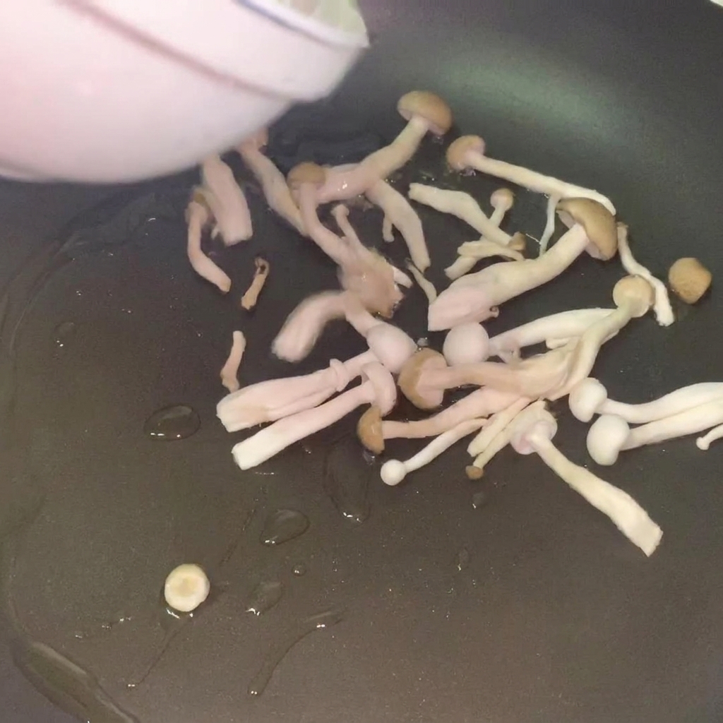 フライパンに熱した油で、きのこがきつね色になるまで炒められている様子。