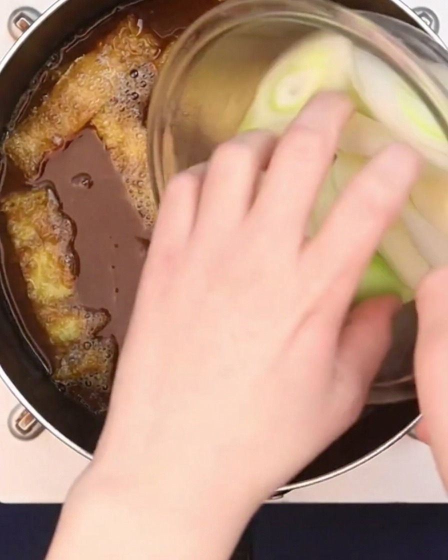 斜め切りにした長ねぎをカレーつゆに加えている様子。
