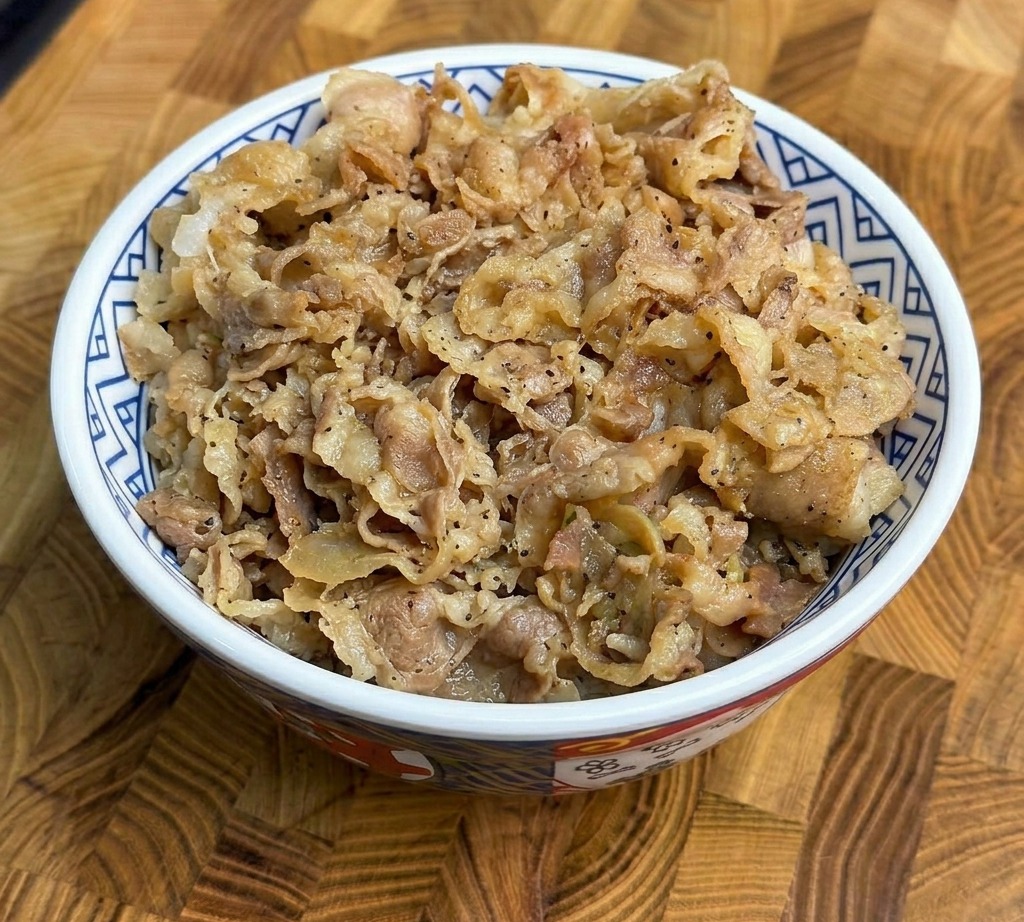 ご飯の上に炒めた牛肉を盛り付けた様子。