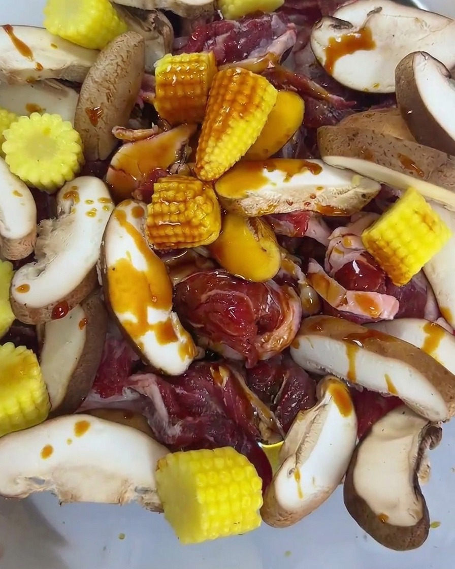 牛肉、椎茸、ベビーコーンに醤油とオイスターソースをかけている様子。