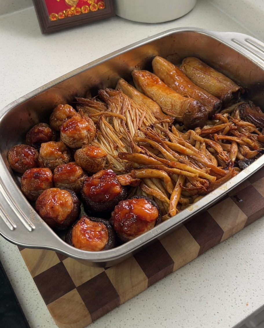金属トレイにのった焼き上がったキノコに、赤い唐辛子パウダーを振りかけているクローズアップ画像。