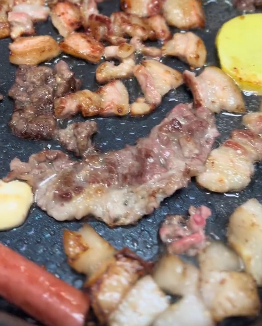 電気グリルで豚バラ肉、マッシュルーム、ジャガイモが香ばしく焼けている様子。