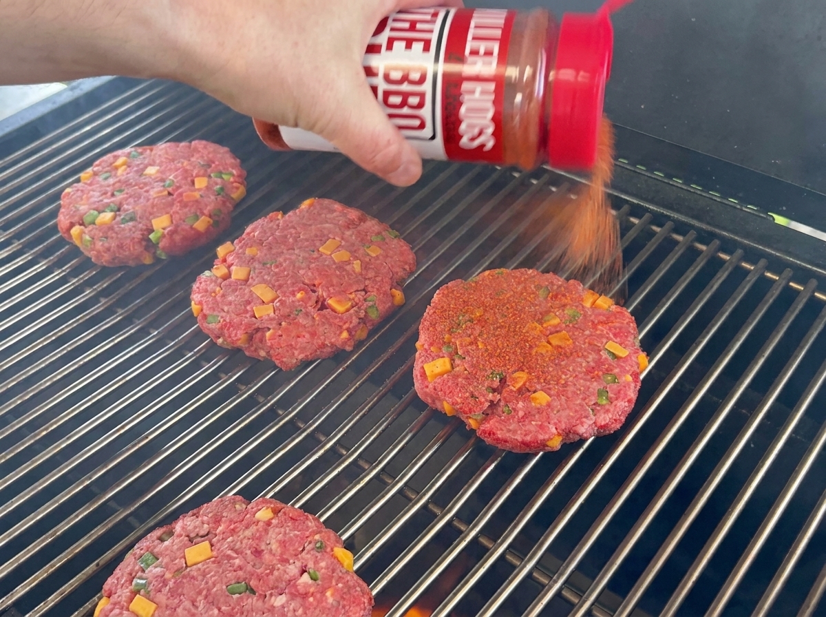 BBQラブが振りかけられ、網の上に乗っているビーフパティ。