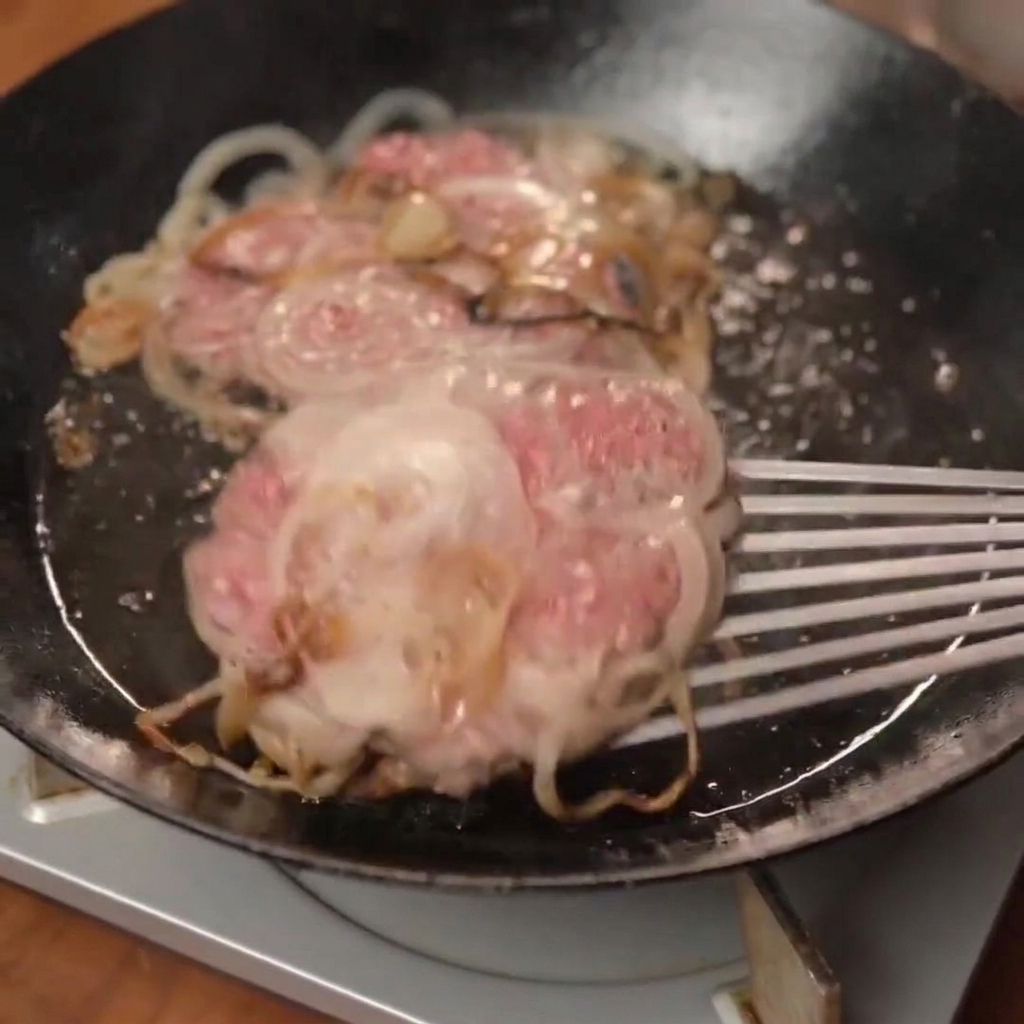 焼きたてチーズパティをトーストしたバンズにのせている様子。