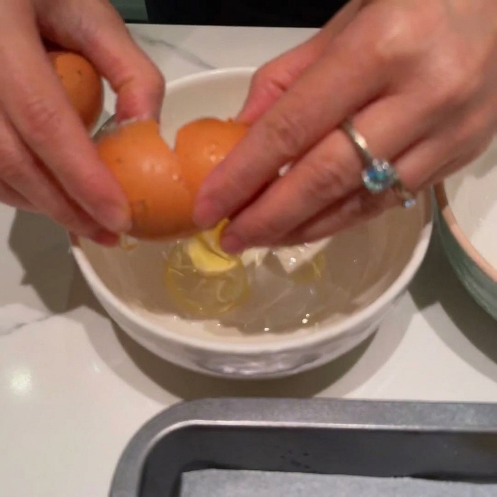 ボウルの中で2つの卵を泡立て器でよく混ぜている様子。