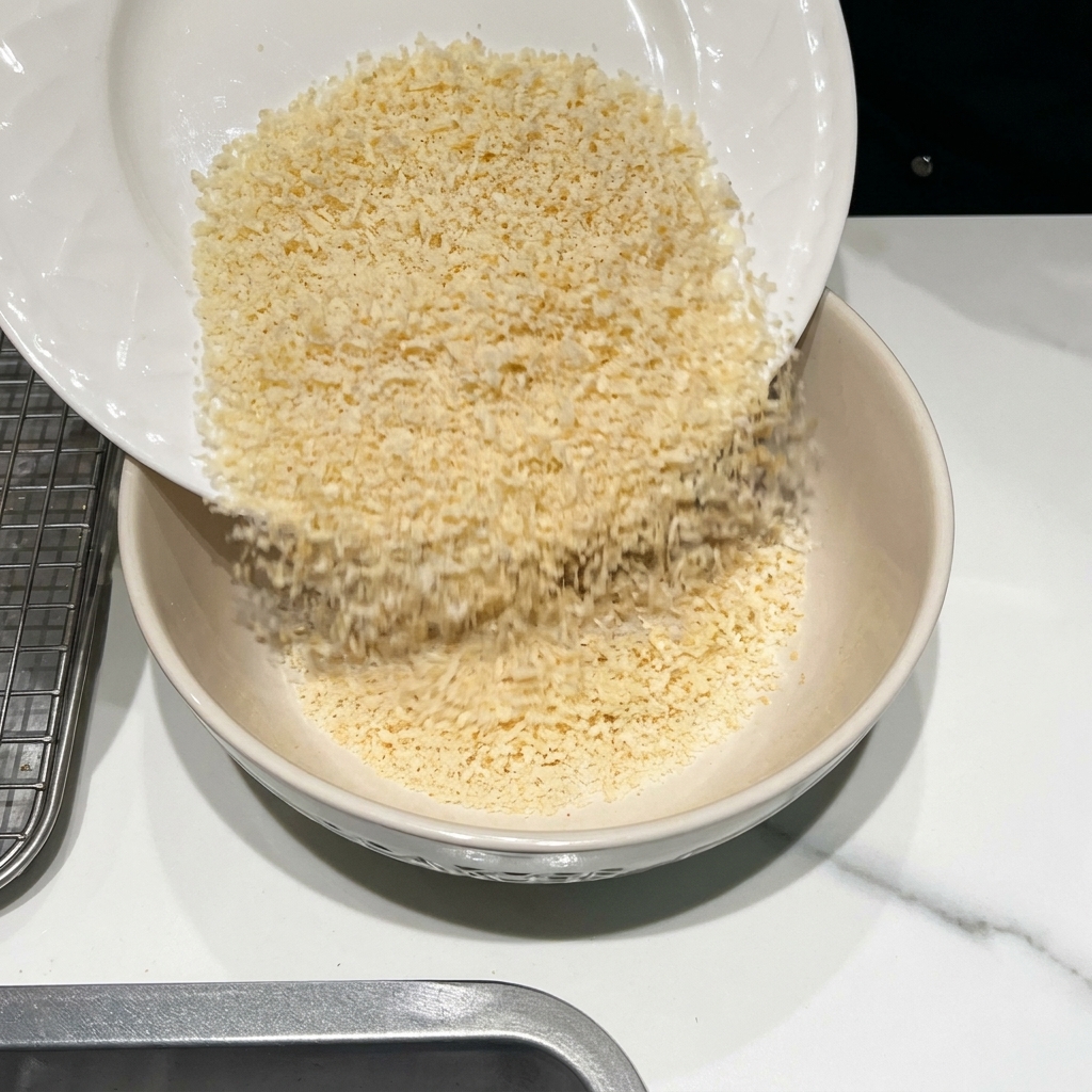 パン粉、粉チーズ、スパイスをボウルで混ぜ合わせている様子。