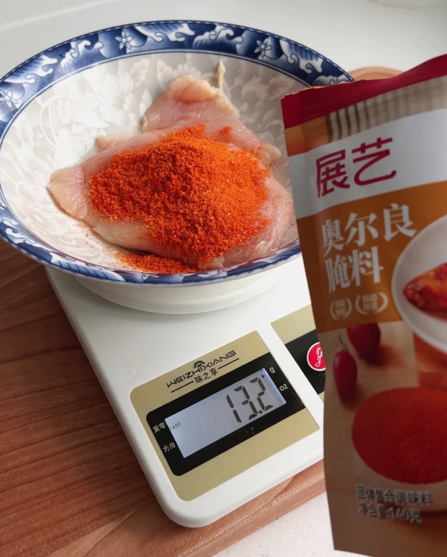 デジタルスケールの上でボウルに入った鶏肉にマリネパウダーを計量している様子。