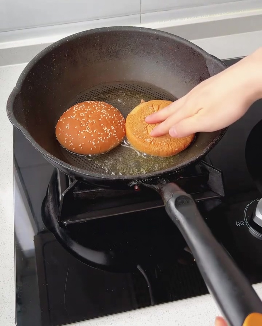 バターを敷いたフライパンでバンズの断面を焼いている様子。