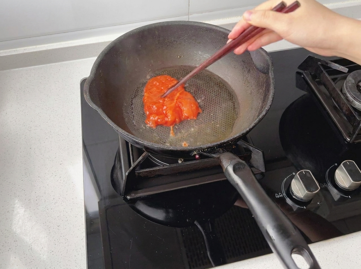 油をひいた予熱済みのフライパンにマリネした鶏肉を入れている様子。