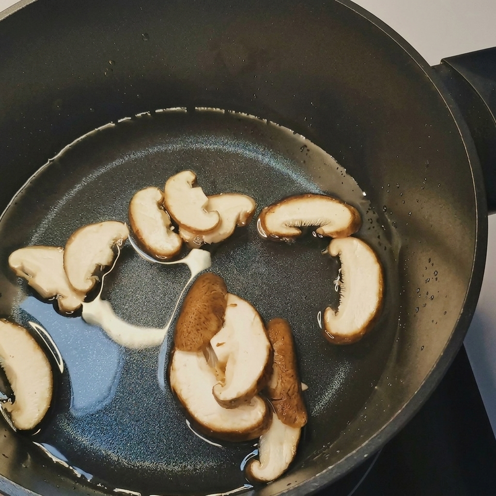 沸騰した鍋に、スライスしたきのこと、もやし、トウモロコシを投入している様子。