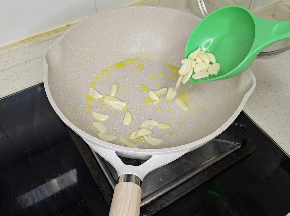 フライパンで炒められているにんにくとねぎ。