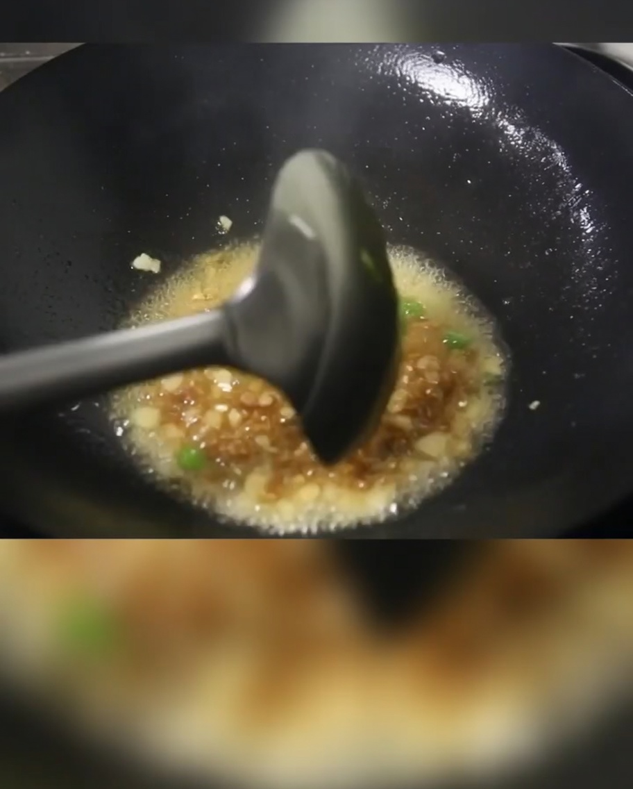 中華鍋で長ねぎ、豚肉、じゃがいもを油で炒めている様子。