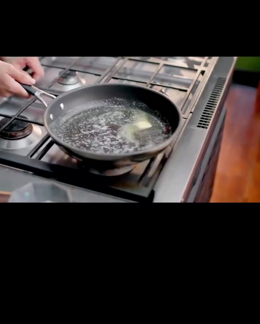 フライパンでバターと小麦粉を泡立て器で混ぜ、なめらかなルーを作っている様子。