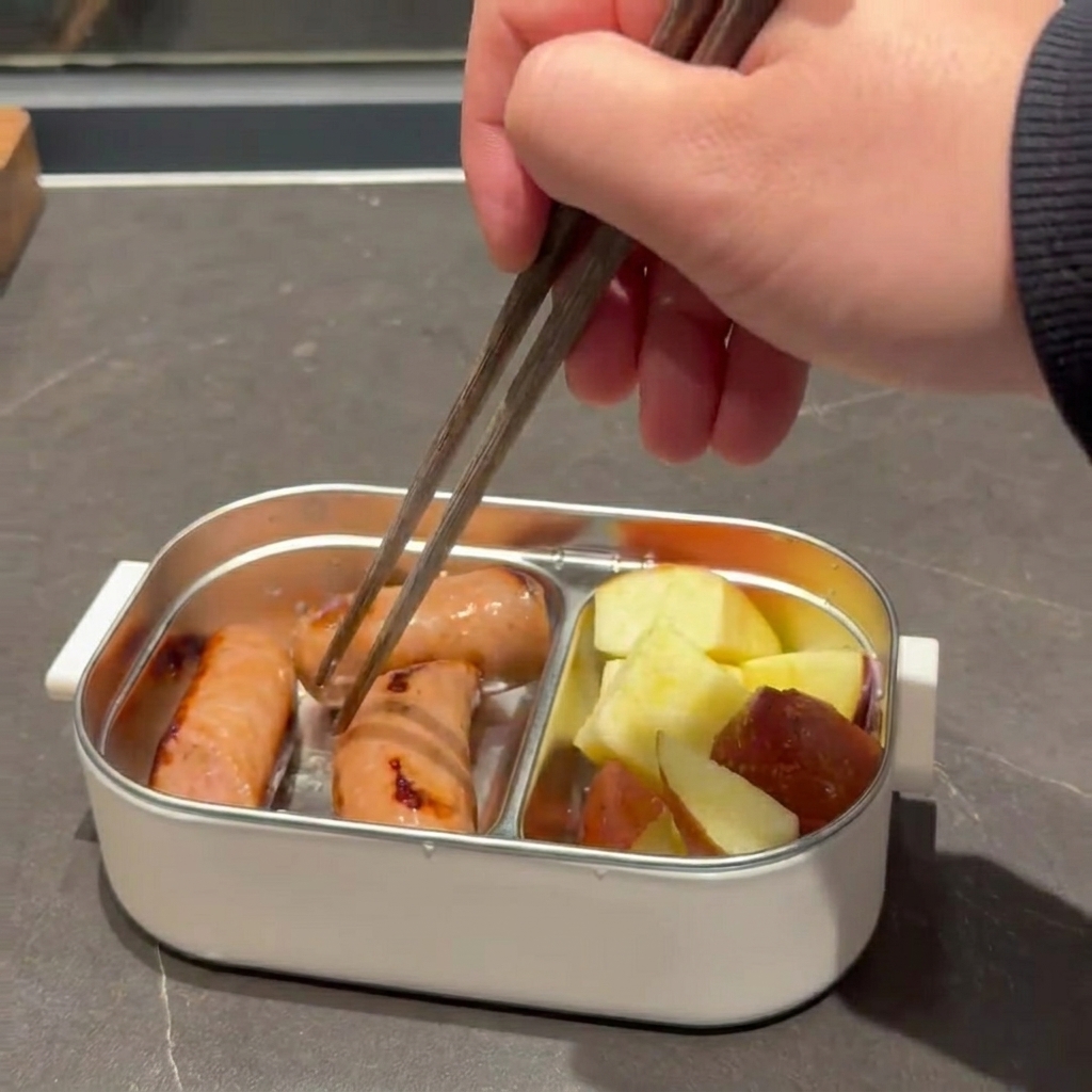 金属製の焼き型に入れたマカロニの上に、シュレッドモッツァレラを振りかけている様子。