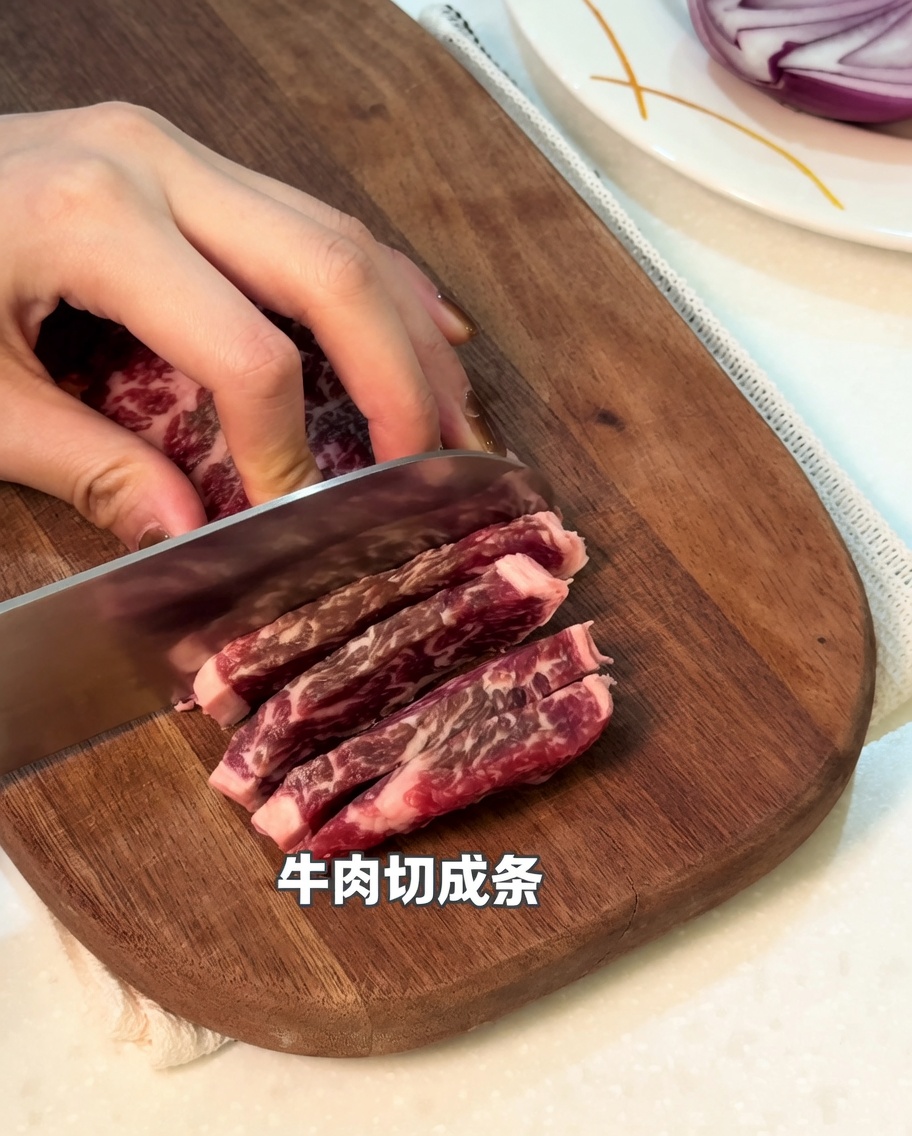 まな板の上で生の牛肉を細切りにしている様子