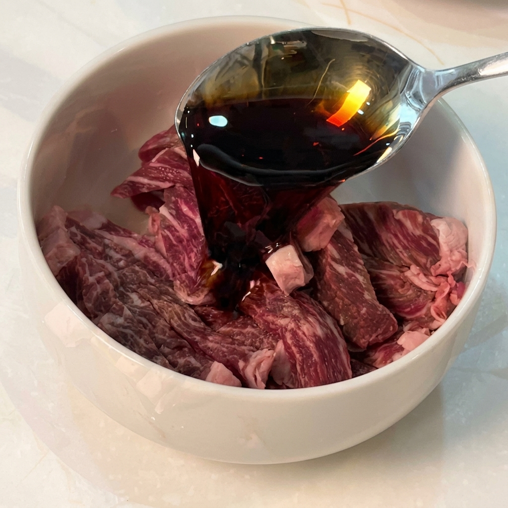 ボウルに入った牛肉に調味料を合わせている様子