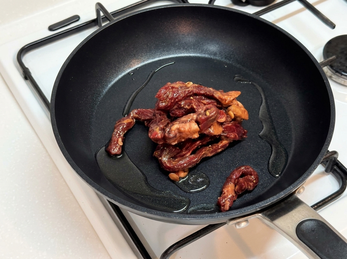 熱したフライパンで牛肉を焼いている様子