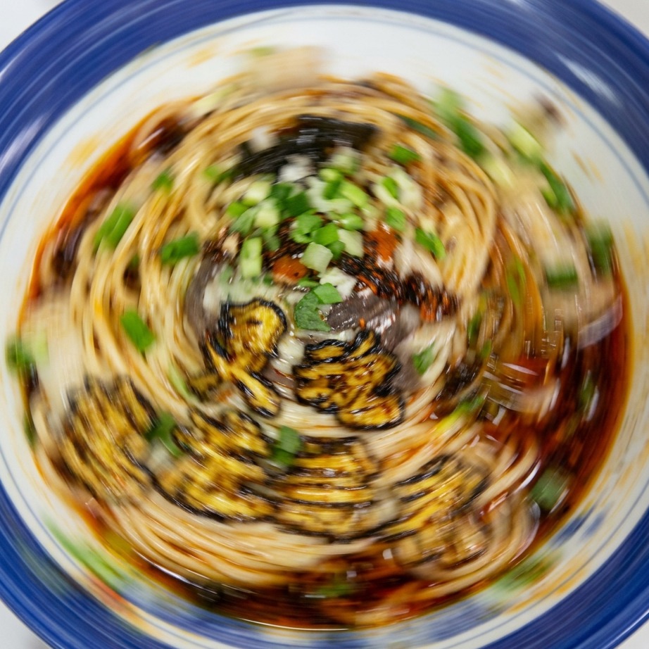 味付けした麺の上に、色鮮やかな刻みネギをのせた様子。