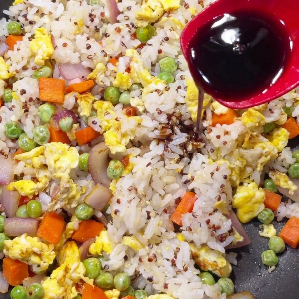 スプーンからキヌアと野菜の炒め物にかけられる醤油。
