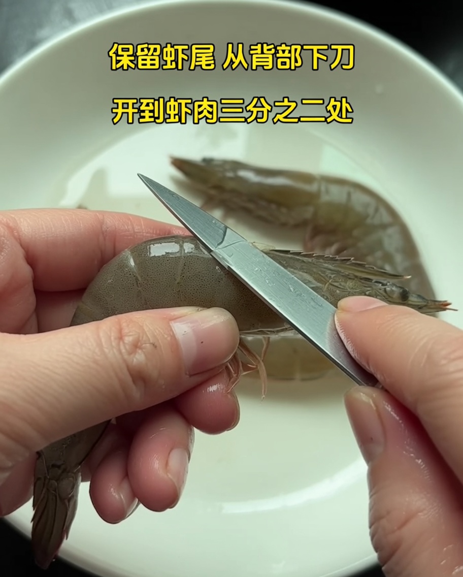 尾を残して海老の殻を剥いている手元のクローズアップ。